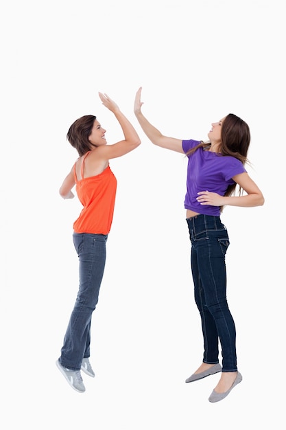 Teenagers jumping while giving each other a high-five