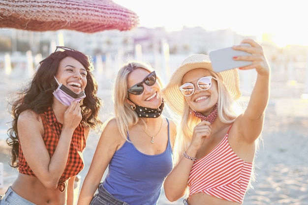 Adolescenti che prendono un selfie in spiaggia