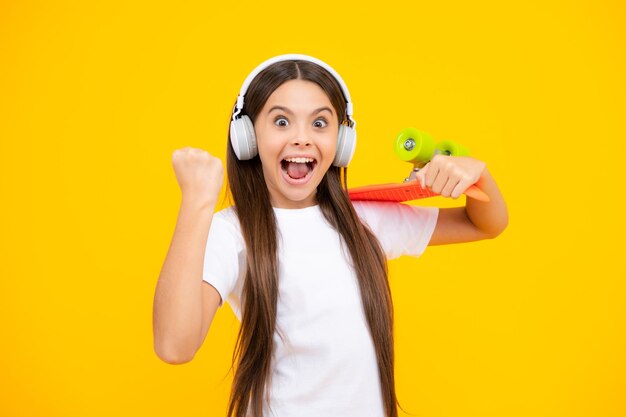 Teenagers youth casual culture Teen girl with skateboard over isolated studio background Teenager in fashion stylish clothes Excited teenager glad amazed and overjoyed emotions