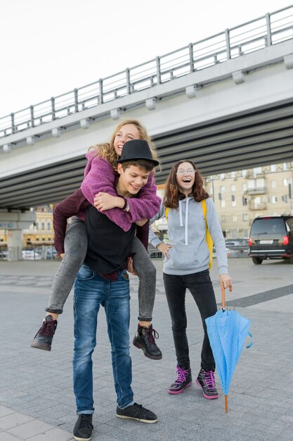 Teens boy and two girls talking and having fun outdoor