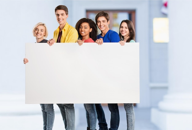 Teens holding blank banner on background