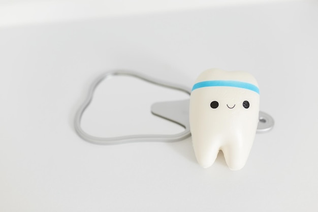 Уход за зубами и гигиена зубов игрушечный зуб и зеркало на белом фоне стоматологическая концепция