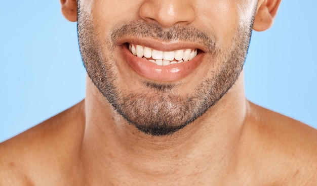 Teeth mouth and beard of a man with a smile for dental health and wellness against a blue studio background Healthcare lips and face of a happy and clean model with results from care for tooth