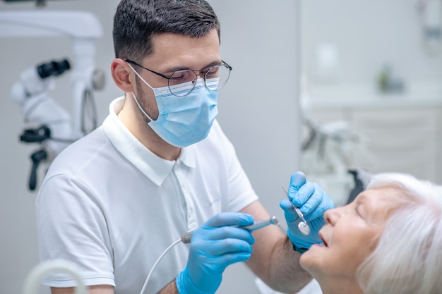 Teeth restoration. Dentist restoring teeth to the senior female patient