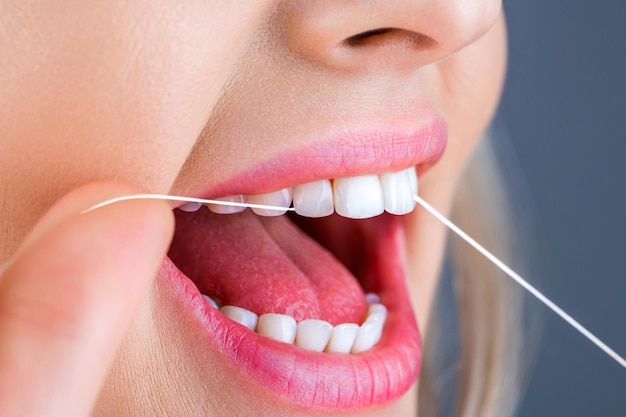 teeths flossing oral hygiene and health care smiling women use dental floss white healthy teeth dental flush woman flossing teeth dental floss taking care of teeth healthy teeth concept