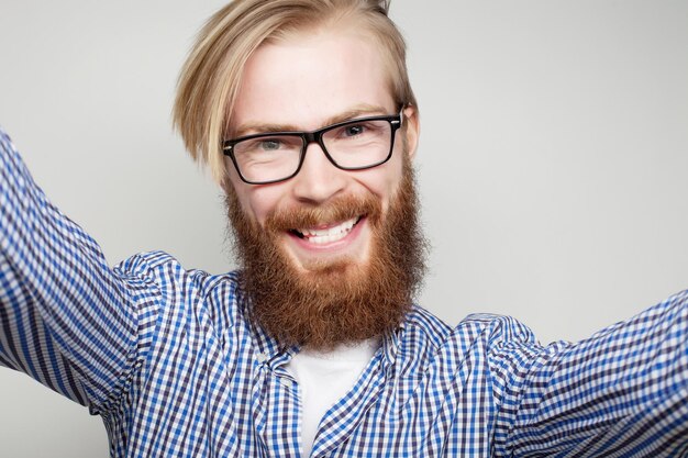 Tehnology-concept: gelukkige selfie. Knappe jonge man die camera vasthoudt en selfie maakt en glimlacht.