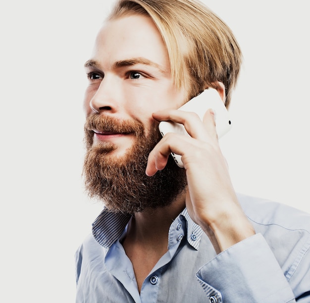 Tehnology, internet, emotional  and people concept: young bearded man talking on mobile isolated on white surface