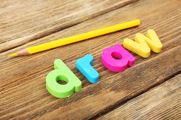 Teken woord gevormd met kleurrijke letters op houten achtergrond