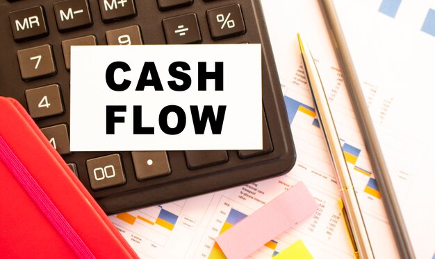 Tekst CASH FLOW op witte kaart met metalen pen. Bedrijfs- en financieel concept