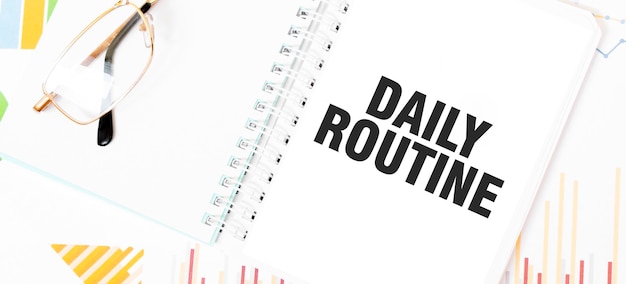 Tekst dagelijkse routine op wit notitieboek bril grafieken en diagrammen