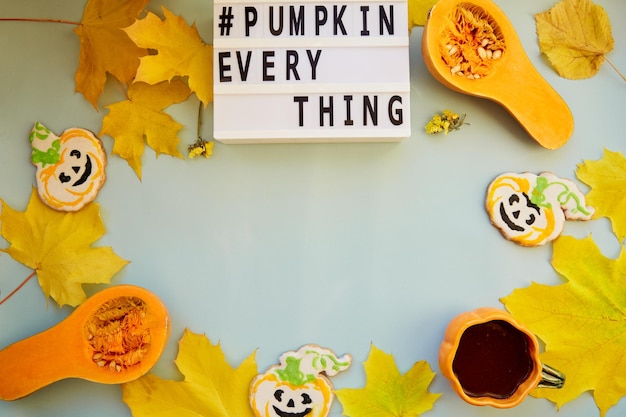 Tekst pompoen alles tussen herfstdecoraties en eten Oranje theekopje met zelfgemaakte koekjes verse pompoenen gele bladeren en kastanjes Kopieer de ruimte