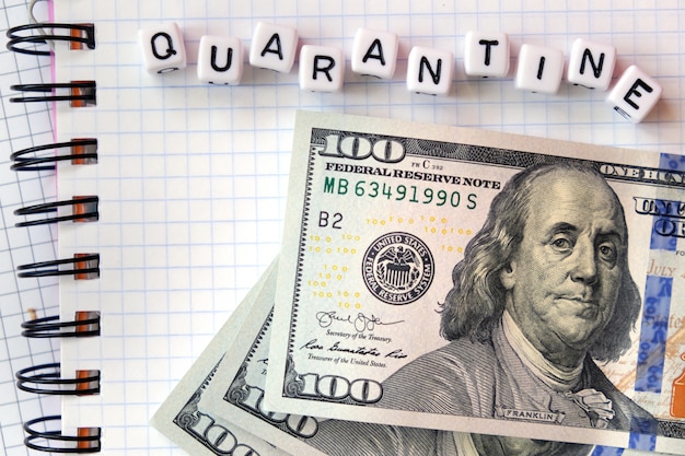 Tekst "Quarantaine", woord gemaakt van kubieke letters en Amerikaans geld dollarr