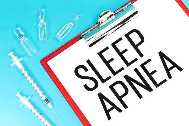 Tekst sleep apnea op klembord, spuit, ampullen.