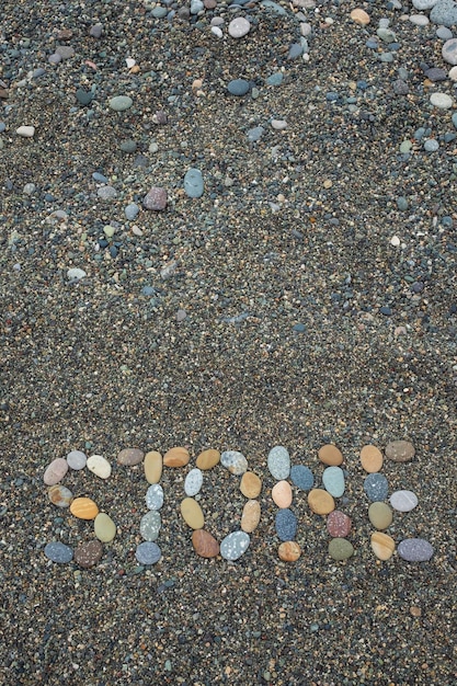 Foto tekststeen gemaakt van stenen op zandstrand