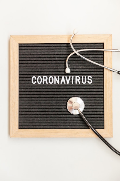 Tekstuitdrukking coronavirus en stethoscoop op zwarte letterbord achtergrond. nieuw coronavirus respiratoir syndroom coronavirus afkomstig uit wuhan, china