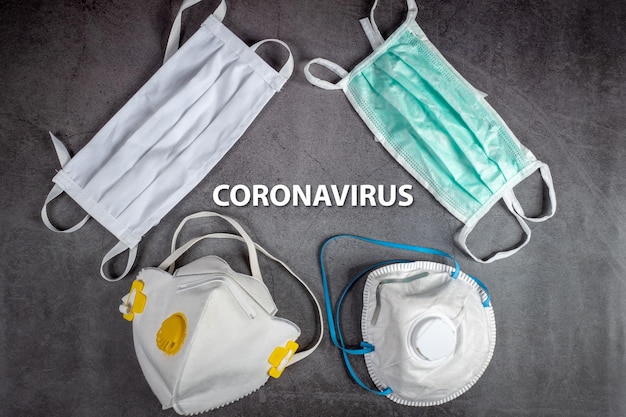 Tekstuitdrukking Coronavirus op zwarte achtergrond met beschermende medische maskers en ademhalingsmaskers