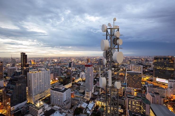 Foto telecommunicatietoren met 5g cellulaire netwerkantenne op de achtergrond van de nachtstad