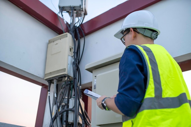 Telecommunication engineers work at cell towers for 5G cell phone signalsNetwork tower maintenance technicians
