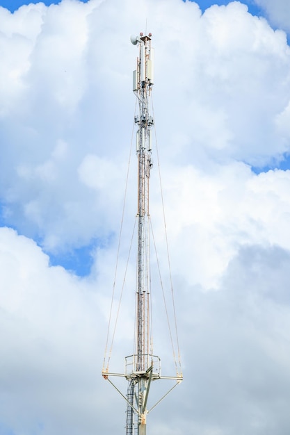 Telecommunication tower of 4G and 5G cellular Macro Base Station 5G radio network telecommunication equipment with radio modules and smart antennas mounted on a metal against cloulds sky background