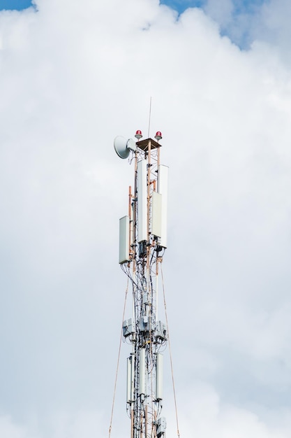 Telecommunication tower of 4G and 5G cellular Macro Base Station 5G radio network telecommunication equipment with radio modules and smart antennas mounted on a metal against cloulds sky background