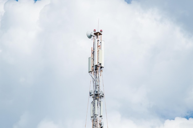 Telecommunication tower of 4G and 5G cellular Macro Base Station 5G radio network telecommunication equipment with radio modules and smart antennas mounted on a metal against cloulds sky background