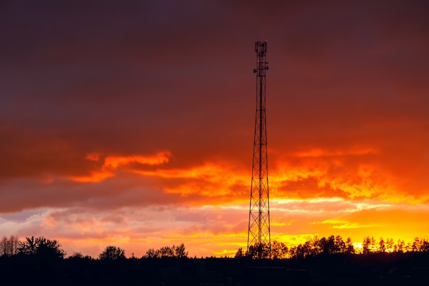 Telecommunication tower against the beautiful sunset sky, cell antenna, transmitter. Telecom TV radio cellular mobile tower.