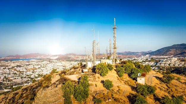 Photo telecommunication tower on mountin with 4g 5g cellular network antenna on city background