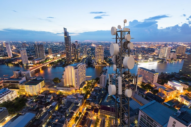 Telecommunication tower with 5G cellular network antenna on city background