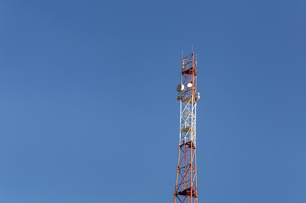 Photo telecommunications tower with antennas against the blue sky