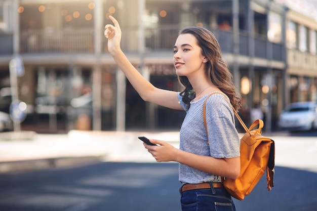 Telefoon glimlach en taxi met vrouw op de stoep van de stad voor pendelen sightseeing of reizen App hand gebaar en rijden delen met gelukkige toerist persoon hailing taxi of vervoer buiten in de stedelijke stad