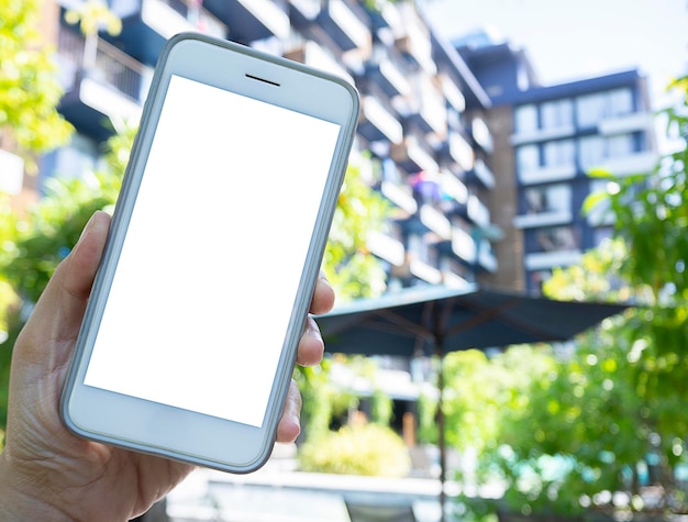 Telefoon in handen met een geïsoleerd scherm op de achtergrond van het gebouw