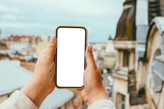 Telefoon met een scherm in de handen op de achtergrond van de stad