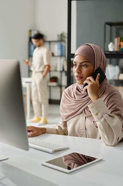 Telefoon praten voor de computer.