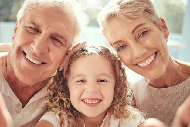 Telefoon selfie grootouders en meisjeskindfamilie houden ervan om gelukkig te glimlachen en samen te binden ter ondersteuning van zorg en geluk Opgewonden kind gepensioneerde senior oma en grootvader nemen foto op sociale media