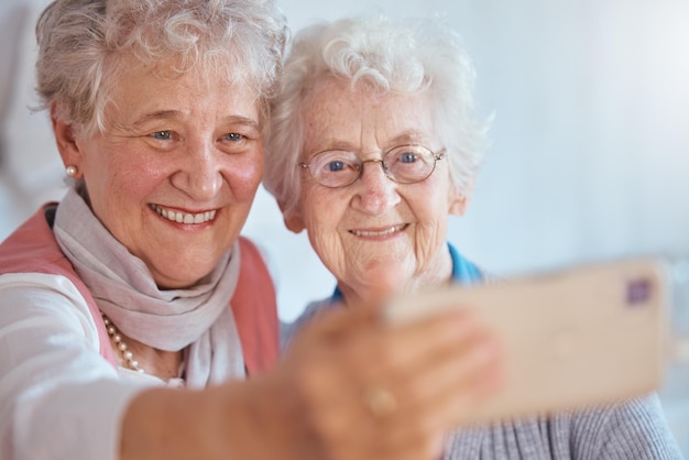 Telefoon selfie oudere vrouwen en vrienden glimlachen voor komische fotografie in bejaardentehuis samen Gelukkige senior vrouw en 5g internet app voor quality time geheugen lachen en vriendschap op smartphone