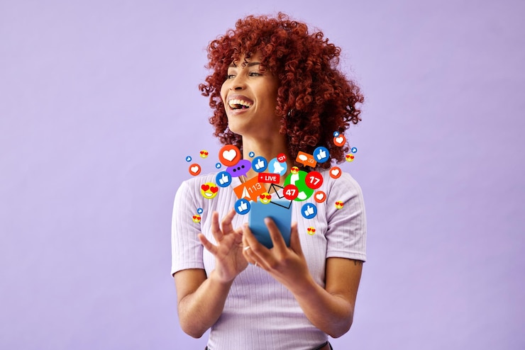 Foto telefoon sociale media en emoji reactie met een zwarte vrouw in de studio op een paarse achtergrond voor communicatie mobiele app en kennisgeving met een gelukkige jonge persoon die technologie gebruikt om een post leuk te vinden