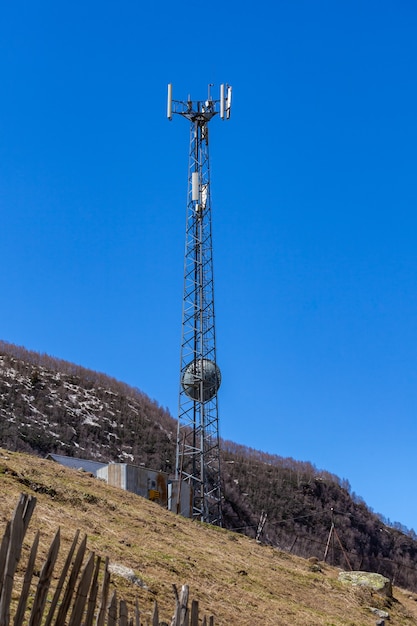 Telefoonantenne, blauwe lucht en witte wolken in Ushguli, Svaneti, Georgia