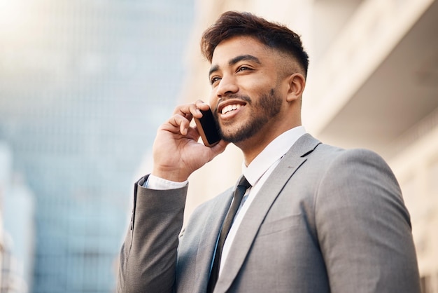 Telefoongesprek gelukkige en jonge zakenman in de stad in een bedrijfsoverleg of gesprek Glimlachtechnologie en professionele mannelijke advocaat praten op een mobiele telefoon voor communicatie in een stedelijke stad