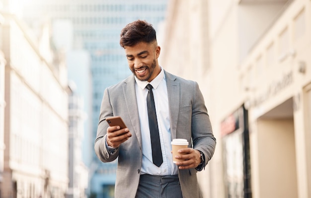 Telefoonzaken en gelukkige man met koffie in de stad online voor sociale media nieuws en website in de stad Reisprofessional en mannelijke werknemer met drankje en smartphone voor internet op ochtendverkeer