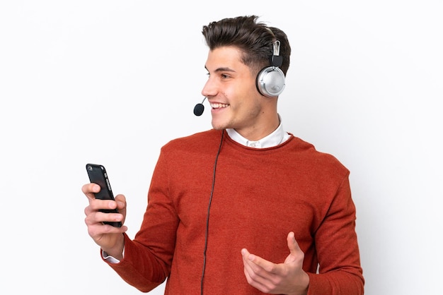 Telemarketeer blanke man aan het werk met een headset geïsoleerd op een witte achtergrond een gesprek voeren met de mobiele telefoon met iemand