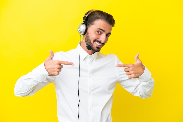 Telemarketeer blanke man aan het werk met een headset geïsoleerd op gele achtergrond trots en zelfvoldaan