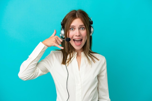 Telemarketeer Engelse vrouw die werkt met een headset geïsoleerd op een blauwe achtergrond die een telefoongebaar maakt Bel me terug teken