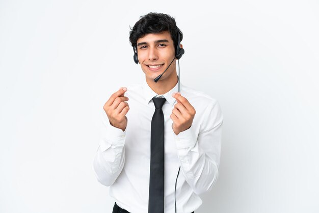 Telemarketeer man aan het werk met een headset geïsoleerd op een witte achtergrond geld gebaar maken