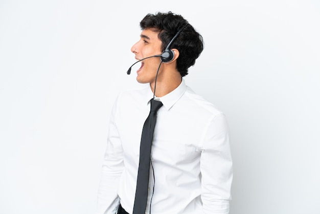 Telemarketeer man aan het werk met een headset geïsoleerd op een witte achtergrond lachen in laterale positie