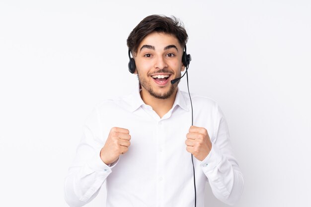 Telemarketeer man aan het werk met een headset geïsoleerd vieren een overwinning