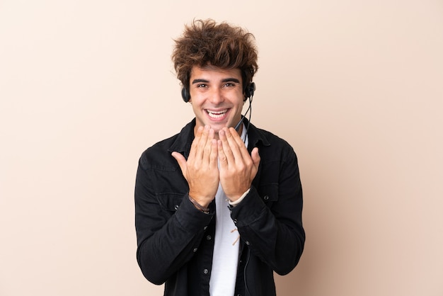 Telemarketeer man aan het werk met een headset over geïsoleerde muur met verrassing gezichtsuitdrukking