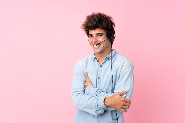 Telemarketeer man aan het werk met een headset over geïsoleerde muur