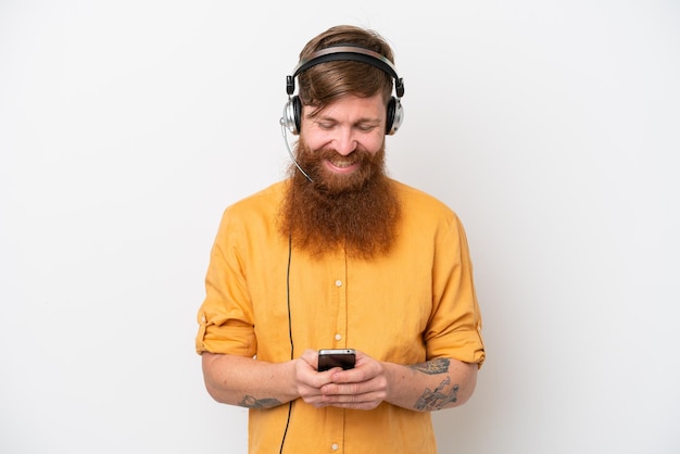 Telemarketeer man geïsoleerd op een witte achtergrond die een bericht verzendt met de mobiel