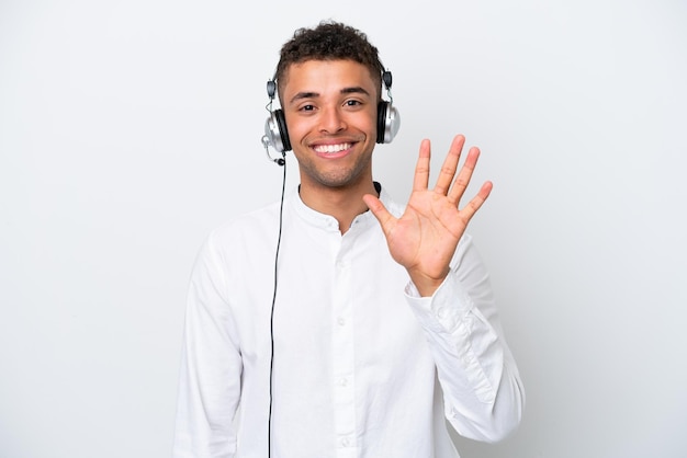 Telemarketer Brazilian man working with a headset isolated on white background counting five with fingers