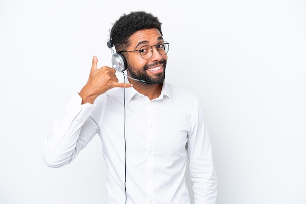 Telemarketer Brazilian man working with a headset isolated on white background making phone gesture Call me back sign